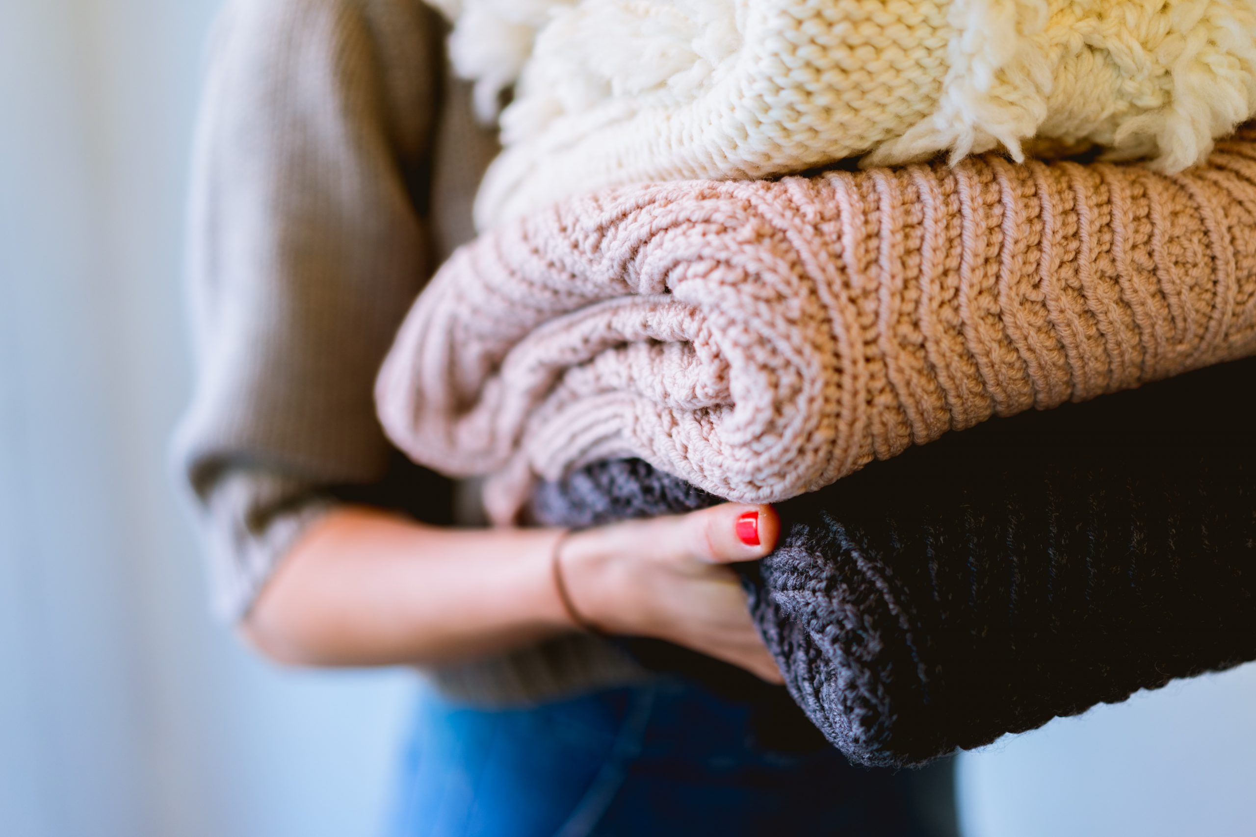 woman carrying sweaters