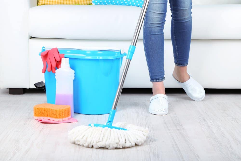 blue bucket, soap and woman pushing a mop