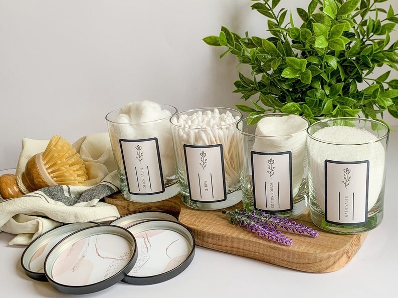 four bathroom storage jars that are labeled