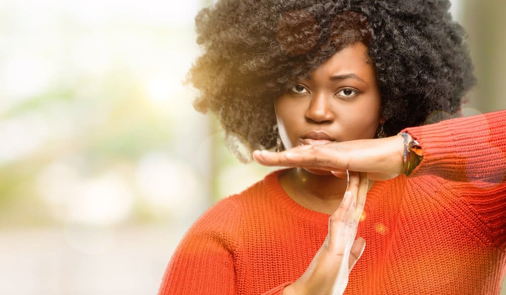 woman in orange shirt doing time out with her hands