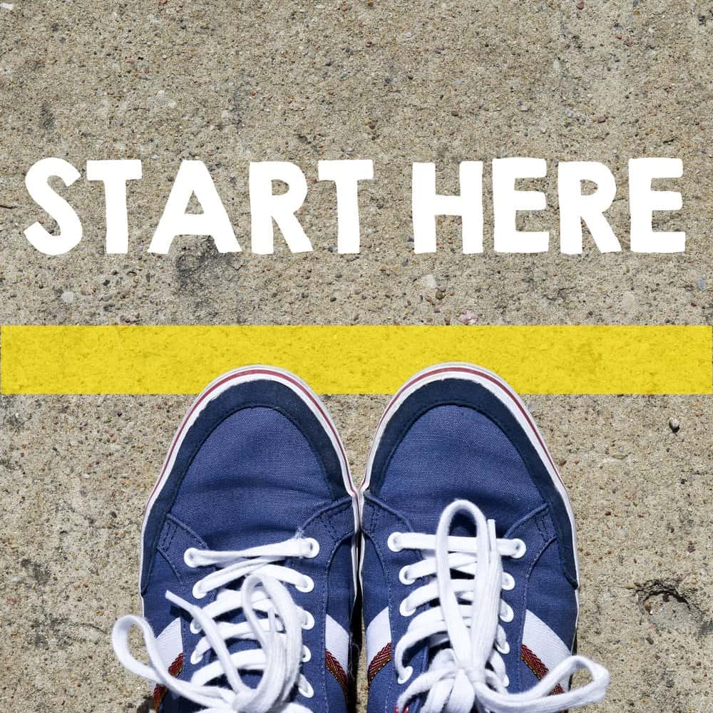 start here in white with a yellow starting line and a pair of blue shoes