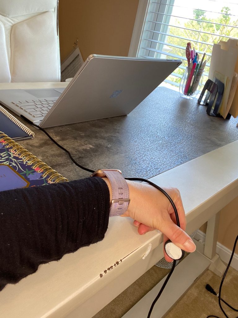 image of desk and computer with persons hand pulling cable clip off desk and leaving behind sticky material
