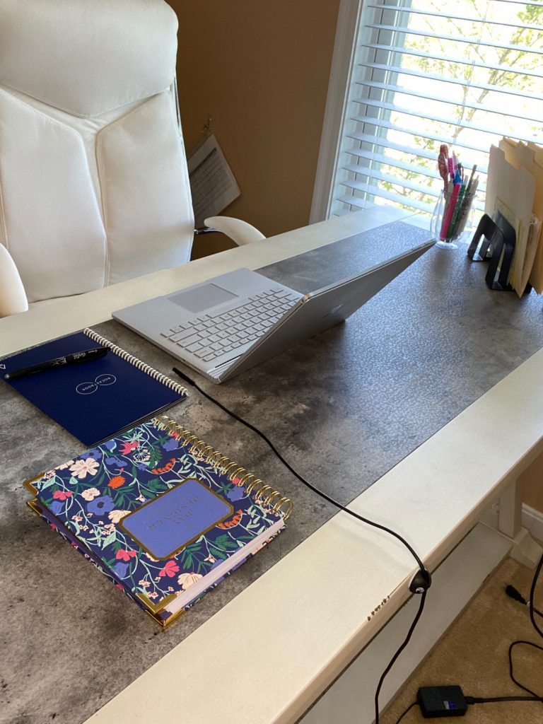 feature image of desk with laptop and two notebooks and a wire being held in place by a wire holder