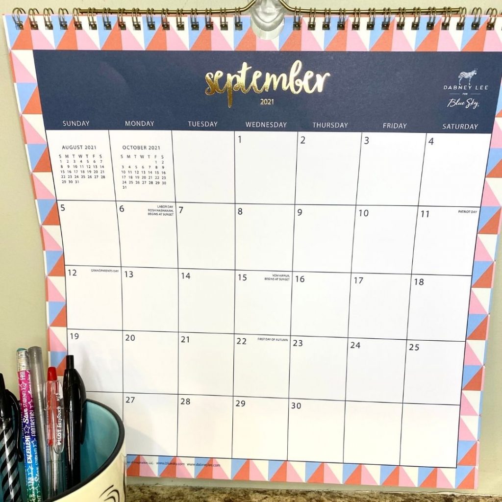 pink and blue framed september calendar page with cup of pens